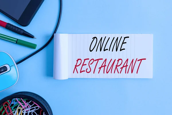 Conceptual hand writing showing Online Restaurant. Concept meaning internet that connects the restaurant or the food company Notebook and stationary with gadgets above pastel backdrop