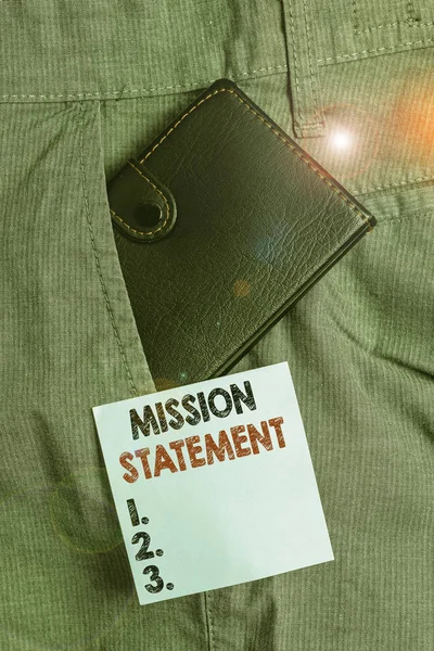 Handwriting text Mission Statement. Conceptual photo formal summary of the aims and values of a company Small little wallet inside man trousers front pocket near notation paper