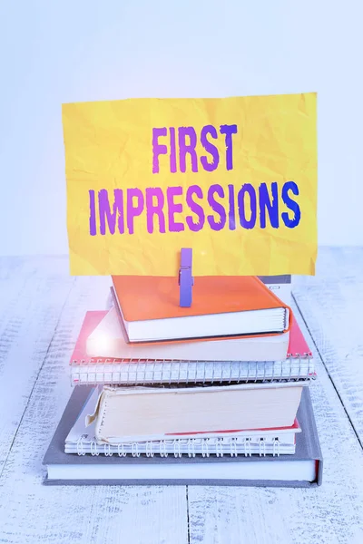 Text sign showing First Impressions. Conceptual photo first consideration or judgment towards a demonstrating pile stacked books notebook pin clothespin colored reminder white wooden.