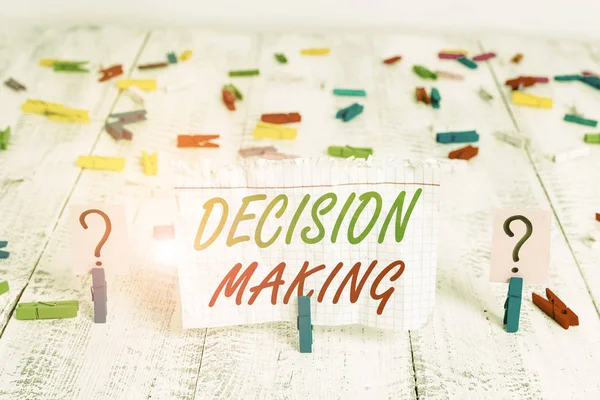 Writing note showing Decision Making. Business concept for process of making decisions especially important ones Crumbling sheet with paper clips placed on the wooden table