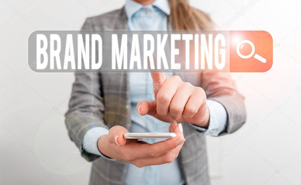 Writing note showing Brand Marketing. Business photo showcasing creating a name that identifies and differentiates a product Business concept with mobile phone and business woman.