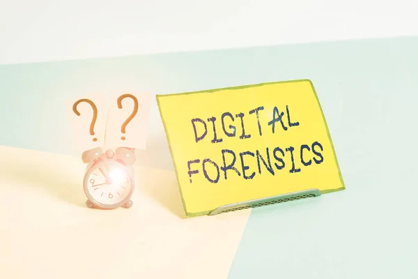 Word writing text Digital Forensics. Business photo showcasing investigation of material found in digital devices Mini size alarm clock beside a Paper sheet placed tilted on pastel backdrop