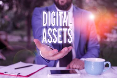 Sözcük yazma Dijital Varlıklar. İş fotoğraflarının değeri vardır ve sahiplenilebilir ama elleri açık fiziksel bir varlığı yoktur. Cep telefonu ve notlar masanın üzerinde.