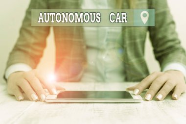 Text sign showing Autonomous Car. Business photo showcasing vehicle that can guide itself without human conduction Business woman sitting with mobile phone on the table
