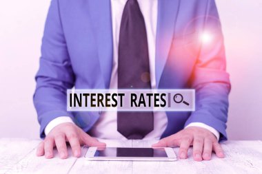 Faiz oranlarını gösteren mesaj işareti. Borç alan, mavi süitli, kravatlı bir iş adamı tarafından alınan kredinin iş fotoğrafı gösterimi oranı dizüstü bilgisayarı elinde tutuyor.