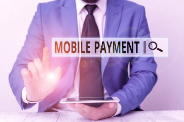 Cep telefonu ödemesini gösteren metin işareti. Ödemenin portatif elektronik cihaz üzerinden yapıldığını gösteren bir iş fotoğrafı. Önünde işaret eden bir iş adamı.