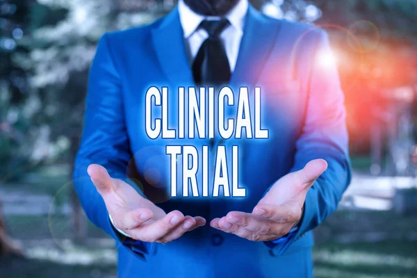 Word writing text Clinical Trial. Business concept for trials to evaluate the effectiveness and safety of medication Man with opened hands stands in suite. Concept with copy space and man.