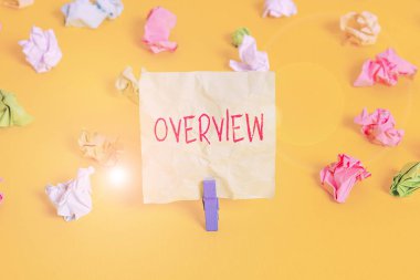 Overview 'i gösteren not yazılıyor. Genel eleştiriyi ya da proje özetini gösteren iş fotoğrafı film kitabı Renkli buruşuk kağıt boş hatırlatıcı beyaz zemin çamaşır mandalı.