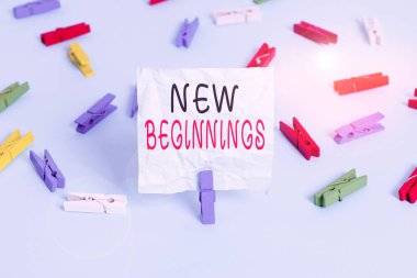 Yeni başlangıçları gösteren kavramsal el yazısı. Geleceğe yeni bir bakış açısı ve içinde renkli çamaşır iğnesi kağıtları bulunan harika imkanlar içeren iş fotoğrafları mavi zemin ofisini anımsatıyor..