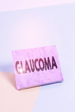El yazısı metni Glaucoma. Bunun anlamı göz hastalıkları optik sinirlerde hasara yol açar. Görme kaybı. Kağıt tampon telin üzerine yerleştirilmiş, yumuşak pastel çok renkli arka plan..