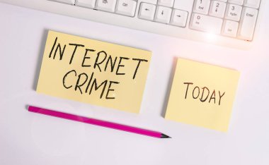 İnternet Suçları 'nı gösteren kavramsal el yazısı. İnternet 'te suç ya da yasadışı online faaliyet gösteren iş fotoğrafları fotokopi alanı yapışkan notlarının üzerinde iş konseptiyle yatıyordu..