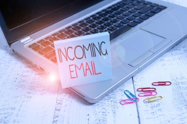 El yazısı Gelen E- posta. Konsept, bir şirket ya da bireysel olarak metalik dizüstü bilgisayar tarafından alınan posta parçalarının boş yapışkan kağıt klipslerinin eski ahşap masadan yapıldığı anlamına gelir..