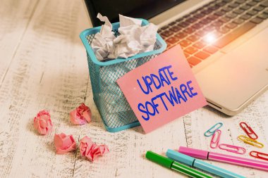 Kelime yazma Güncelleme Yazılımı. Küçük yazılım geliştirmeleri ve uyumluluk eklemek için iş konsepti Laptop yapışkan not septi ezilmiş kağıt top ataçları eski masa raptiyeleri.