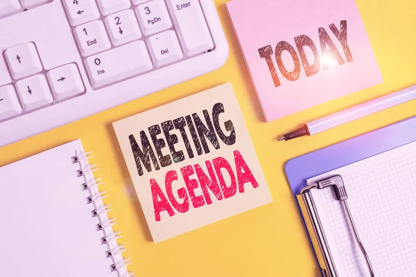 Handwriting text writing Meeting Agenda. Concept meaning list of items that participants to accomplish at a meeting Empty papers with copy space on yellow background table.