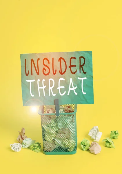 Writing note showing Insider Threat. Business photo showcasing security threat that originates from within the organization Trash bin crumpled paper clothespin office supplies yellow.