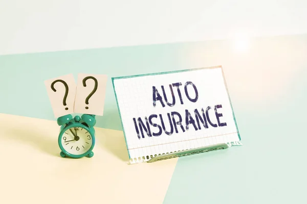 Text sign showing Auto Insurance. Conceptual photo mitigate costs associated with getting into an auto accident Mini size alarm clock beside a Paper sheet placed tilted on pastel backdrop.