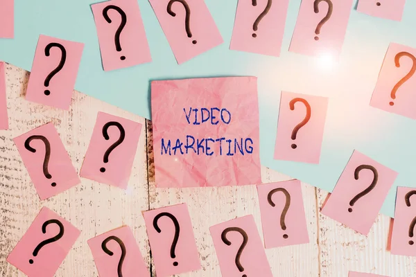 Handwriting text Video Marketing. Concept meaning integrates engaging video into the marketing campaigns Scribbled and crumbling papers with thick cardboard above wooden table.