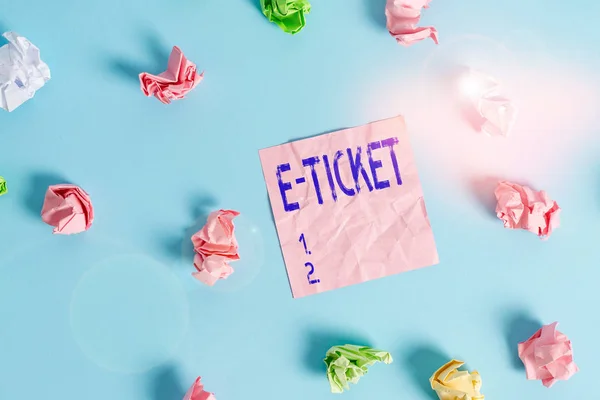 Handwriting text E Ticket. Concept meaning Digital ticket that is as valid as a paper ticket or its equivalent Colored crumpled rectangle shaped reminder paper light blue background. — Stockfoto