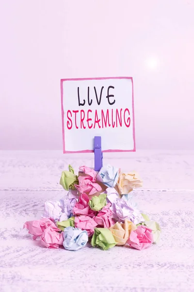 Word writing text Live Streaming. Business concept for media simultaneously recorded and broadcast in real time Reminder pile colored crumpled paper clothespin reminder white wooden space. — ストック写真