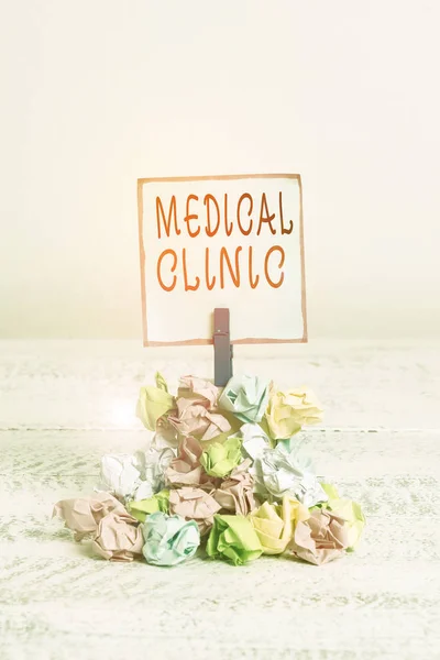 Word writing text Medical Clinic. Business concept for facility that is primarily focused on the care of outpatients Reminder pile colored crumpled paper clothespin reminder white wooden space.