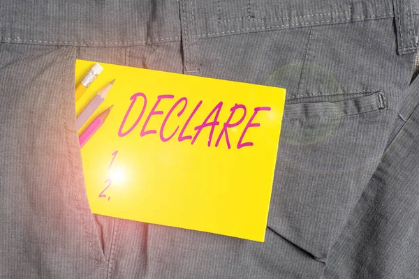 Writing note showing Declare. Business photo showcasing make known or state clearly especially in explicit or formal terms Writing equipment and yellow note paper inside pocket of man trousers. — Stockfoto