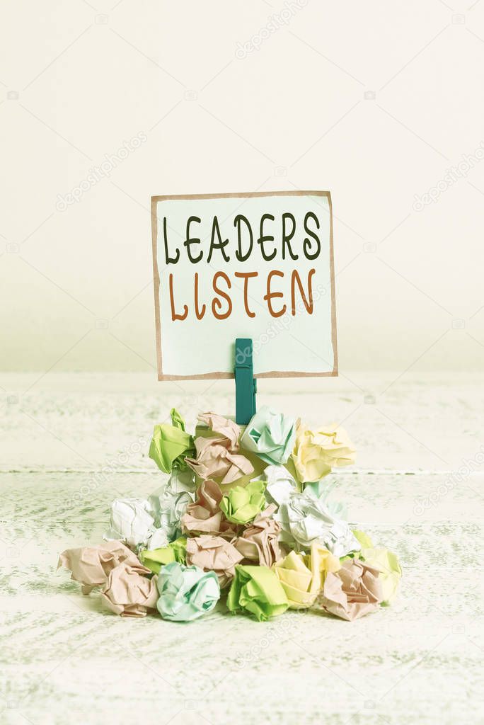Word writing text Leaders Listen. Business concept for knowledge are not gained by talking but by listening Reminder pile colored crumpled paper clothespin reminder white wooden space.