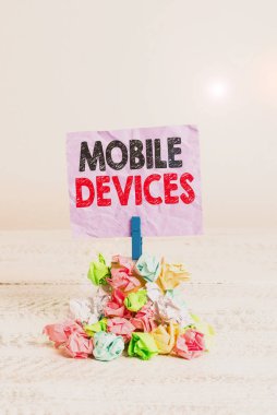 Mobil Aygıtları gösteren not yazılıyor. Akıllı telefon ya da tablet hatırlatıcı yığın renkli buruşuk kağıt çamaşır tokası gibi taşınabilir bilgisayar aygıtlarını gösteren iş fotoğrafı.