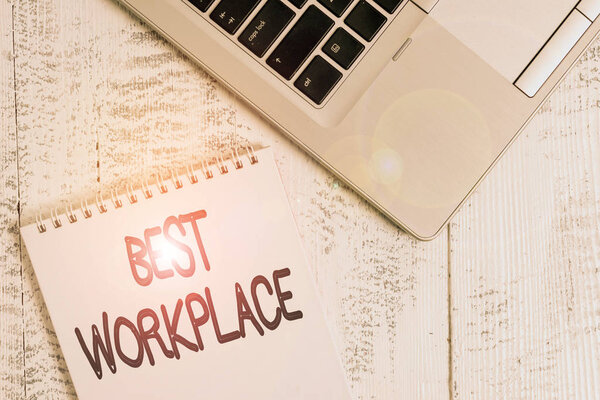 Writing note showing Best Workplace. Business photo showcasing helps employees to grow individually Promotes meritocracy Top trendy metallic laptop blank spiral notepad lying on wooden table.