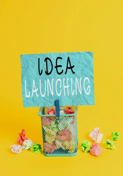 Writing note showing Idea Launching. Business photo showcasing to begin something new such as a plan or business venture Trash bin crumpled paper clothespin office supplies yellow.