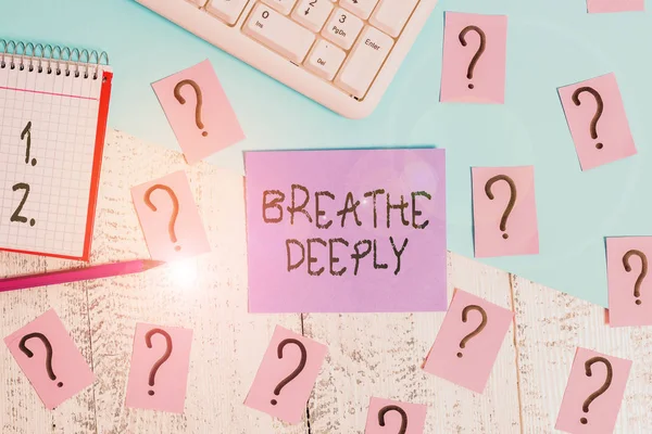 Conceptual hand writing showing Breathe Deeply. Business photo showcasing to take a large breath of air into your lungs To pause Writing tools and scribbled paper on top of the wooden table.