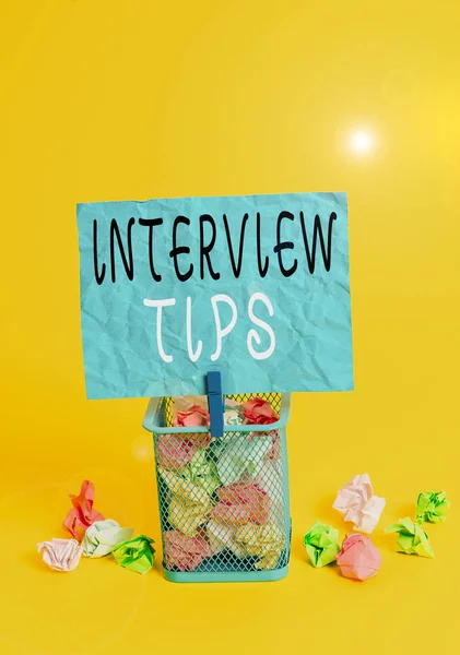 Writing note showing Interview Tips. Business photo showcasing information or advice given to be helpful during interview Trash bin crumpled paper clothespin office supplies yellow.