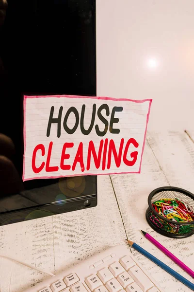 Handwriting text writing House Cleaning. Concept meaning the action or process of cleaning the inside of house or flat Note paper taped to black computer screen near keyboard and stationary.