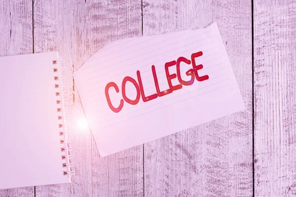 Conceptual hand writing showing College. Business photo text educational institution or establishment providing higher education Torn paper and notebook sheet placed above classic wooden table.