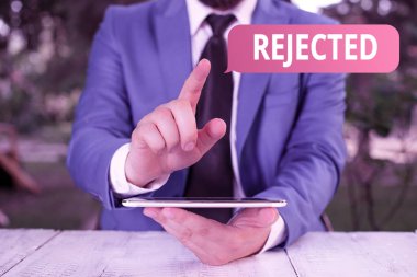 Reddedildiğini gösteren not yazılıyor. İş fotoğrafı gösterimi yetersiz kabul edilemez ya da hatalı olarak reddedilir. İş adamı önünde parmağını göstererek anlaşmayı reddeder..