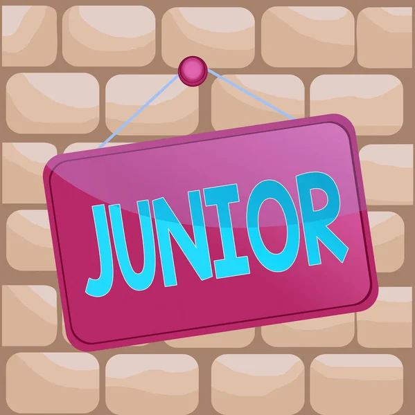 Handwriting text writing Junior. Concept meaning erson who is a specified number of years younger than someone else Colored memo reminder empty board blank space attach background rectangle. — Stock Photo, Image