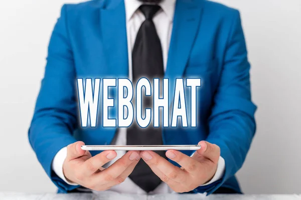 Parola di scrittura di testo Webchat. Business concept per un sistema che consente agli utenti di comunicare in tempo reale utilizzando internet Businessman in blue suite con cravatta in mano . — Foto Stock