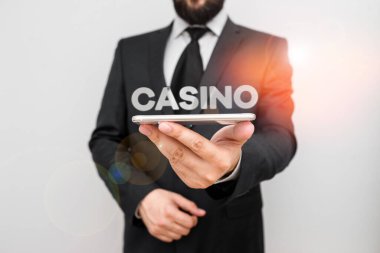 Handwriting text writing Casino. Concept meaning a building where games especially roulette and card games are played Male human wear formal work suit hold smart hi tech smartphone use one hand.