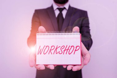 Word writing text Workshop. Business concept for room or building in which goods are analysisufactured or repaired Male human wear formal work suit office look hold mathematics book use hand.