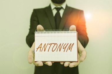 Kelime yazma Antonym. Anlamı başka bir kelimenin zıttı olan kelime ya da ifade için iş konsepti. Erkek giyimi resmi çalışma kıyafeti ofisi. Matematik kitabı kullan..