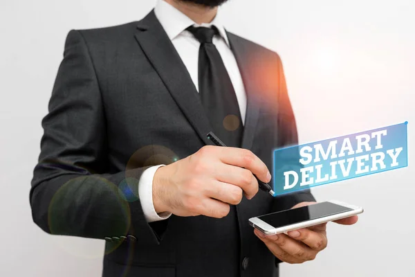 Text sign showing Smart Delivery. Conceptual photo Mobile solution for delivering and transporting goods faster Male human wear formal work suit hold smart hi tech smartphone use one hand. — Zdjęcie stockowe