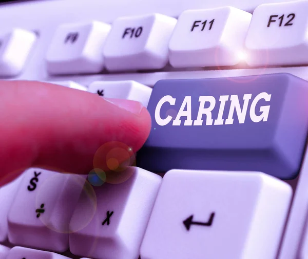 Tekstbord met Caring erop. Conceptuele fotopraktijk van het verzorgen van mensen die niet voor zichzelf kunnen zorgen. — Stockfoto