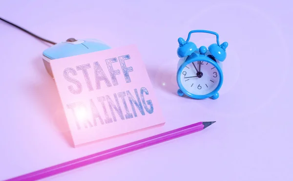 Word writing text Staff Training. Business concept for program that is designed to increase the technical skills Vintage alarm clock wire mouse empty notepad markers colored background.