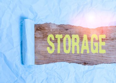 Depo 'yu gösteren bir not yazıyorum. İş fotoğrafı depolama eylemi ileride kullanılacak bir şey. Parçalanmış şeyleri tahta klasik bir masanın üzerine yerleştirmek için güvenli bir şey..