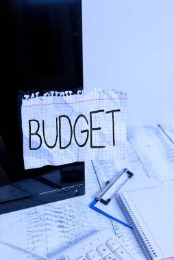 El yazısı bütçesi. Kavram, belirli bir zaman dilimi için gelir ve harcama tahmini anlamına gelir Not kağıdı klavye ve durağan yakınlarındaki siyah bilgisayar ekranına bantlanmış.