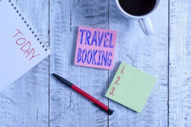 Conceptual hand writing showing Travel Booking. Business photo showcasing arrangement that you make when you book something for travel Stationary placed next to a coffee cup above wooden table.