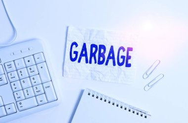 El yazısı çöplüğü. Kavram demek atık madde ya da istenmeyen şeyler demek Çöp beyaz arkaplan üzerinde boş not kağıdı ile beyaz pc klavye.