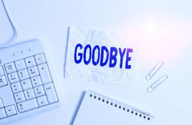 Handwriting text Goodbye. Concept meaning used to express good wishes when parting or end of a conversation White pc keyboard with empty note paper above white background.