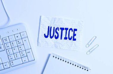 El yazısı Adalet Bakanlığı. Hukukun tarafsız ya da adil yönetiminin niteliği kavramı beyaz arkaplanın üzerindeki boş not kağıdıyla White pc klavyesine hükmeder.