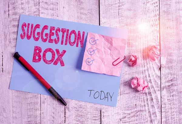 Conceptual hand writing showing Suggestion Box. Business photo showcasing container which showing can leave comments about something Wrinkle paper and cardboard placed above wooden background.