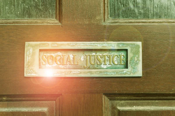 Handwriting text writing Social Justice. Concept meaning Equal access to wealth and privileges within a society Old retro mailbox on the wooden doors. Hole on the wooden doors for mail.